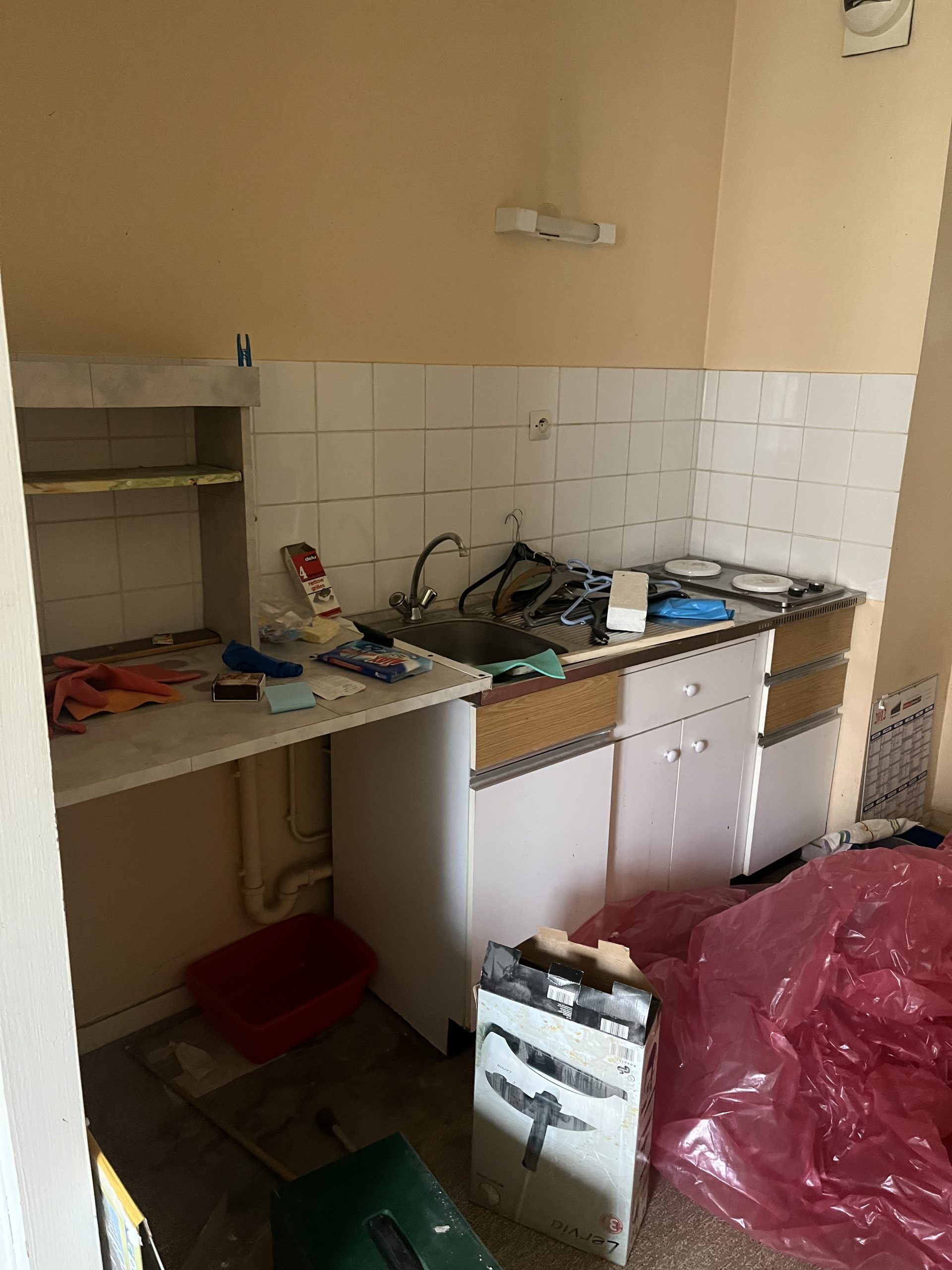 Avant débarras : pièce encombrée et désordonnée avec meubles, cartons et objets éparpillés, état initial avant nettoyage et débarras professionnel.